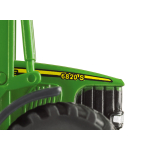 Primer plano del lado frontal de un modelo a escala de tractor John Deere 6820S verde, con una franja amarilla y una rejilla negra.