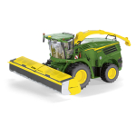 Vista frontal lateral de una picadora de forraje John Deere 8500i verde, con ruedas amarillas y un cabezal Zürn Profi Cut 700.