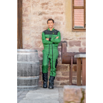 Widok z przodu mężczyzny w zielono-czarnym kombinezonie roboczym John Deere ze skrzyżowanymi ramionami.