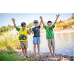 Three children wearing John Deere branded t-shirts and caps stand on a rocky shore with their arms raised.