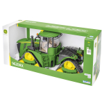 Vista trasera lateral de un tractor de orugas modelo John Deere 9620RX verde con rodillos de oruga amarillos, expuesto en su embalaje.